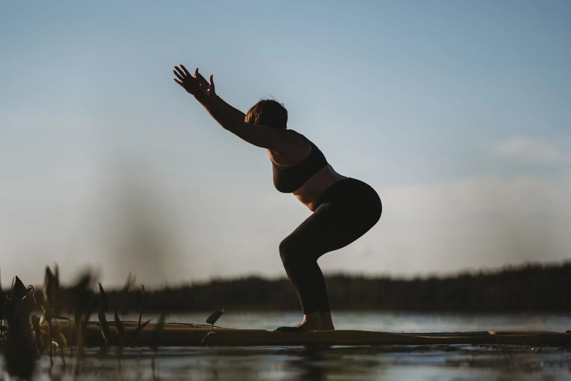 Shelley practising yoga outdoors beside the water